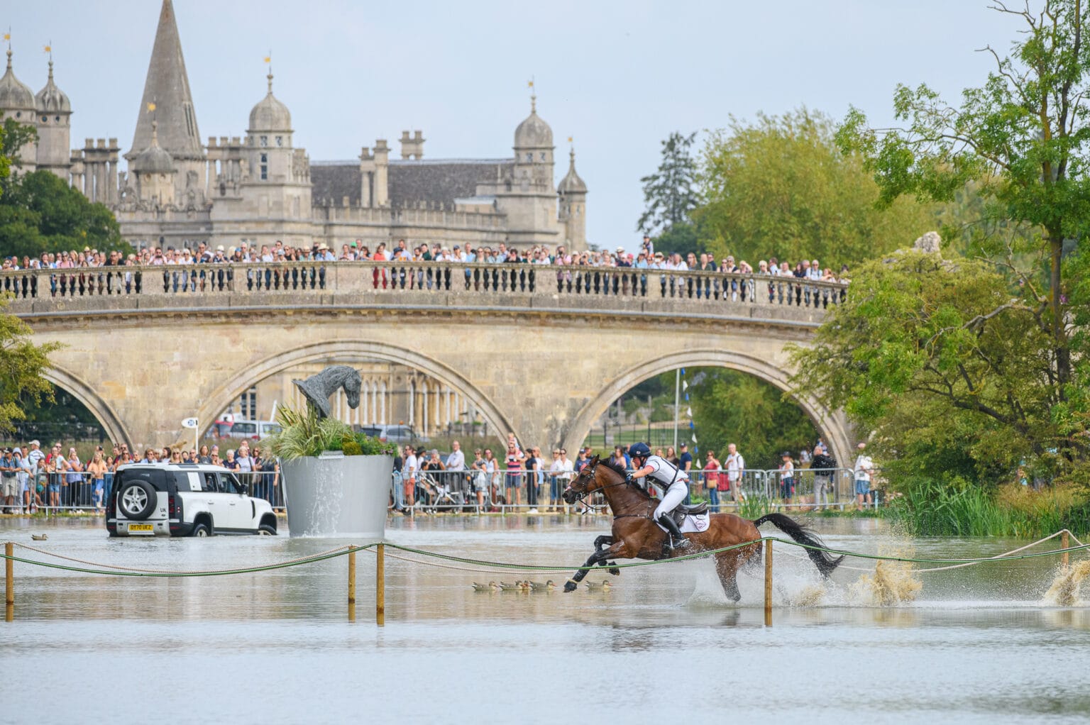 Bubby Upton crosses the lake at Burghley with the Lion Bridge and Burghley House in the background