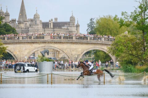 Bubby Upton crosses the lake at Burghley with the Lion Bridge and Burghley House in the background